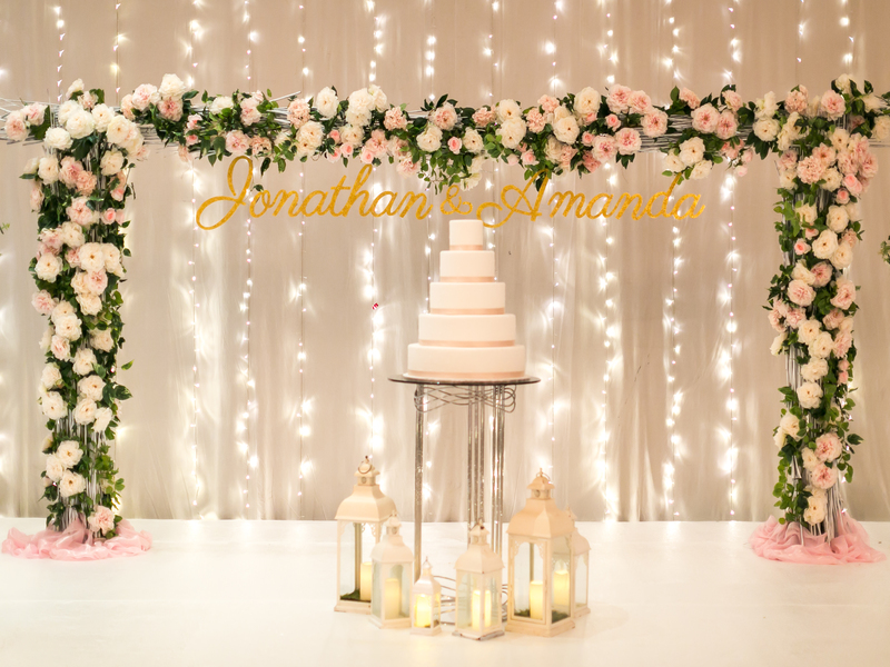 Wedding backdrop fairy lights with flowers and wedding cake for photoshoot photobooth